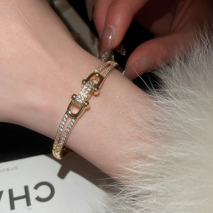 Vue détaillée du bracelet à boucle fer à cheval doré avec pierres de zircone brillantes