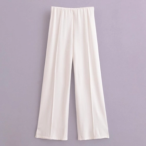 Détail du pantalon blanc large avec plis marqués et taille haute élastique