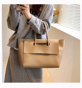 Mirror selfie showing the large beige leather tote bag for daily commute and styling