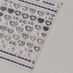 Embossed nail art stickers with purple and black plaid hearts, lace, and bow designs