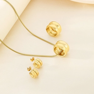 Detailed view of golden double-ring pendant necklace and matching earrings set