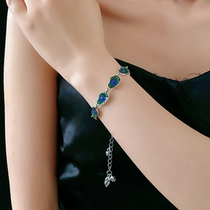 Detail shot of a silver lotus leaf bracelet with blue and green cloisonne enamel accents