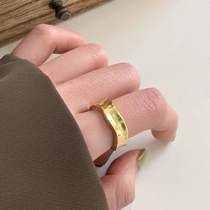 Minimalist 925 sterling silver wavy ring in polished gold worn on a finger