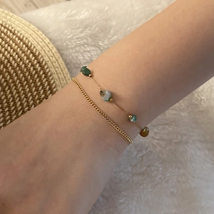 Close-up of gold double-layer bracelet with green natural stones on a white background