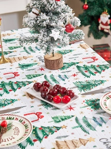 Close-up of Christmas tablecloth featuring festive trees, gift boxes, and stars textures
