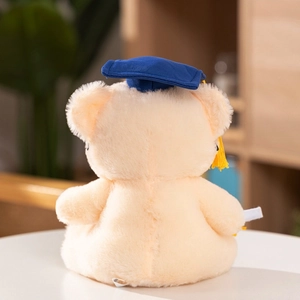 Rear view of graduation teddy bear plush with blue cap and white diploma scroll