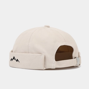 Detail of mountain embroidery and adjustable silver buckle on beige cotton docker cap
