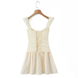 Detail view of beige off-shoulder mini dress featuring criss-cross lace-up back design