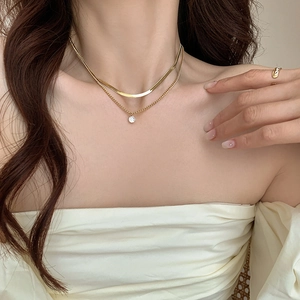 Close-up of double-layer gold snake chain necklace with zircon pendant on model neck