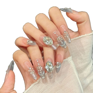 Blue aurora cat eye press-on nails with almond shape, glitter and gemstone accents