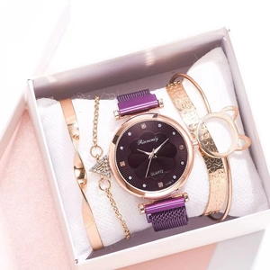 Detail view of purple quartz watch with diamond flower dial and gold bracelet set in box