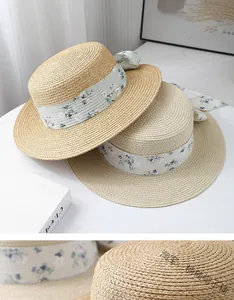 Détail d'un chapeau de paille avec ruban floral et texture tressée pour la plage