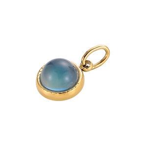 Macro view of gold-plated circular pendant featuring a translucent blue gemstone