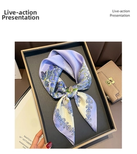 Detail showing a purple floral silk scarf knotted as a decorative accessory for bags