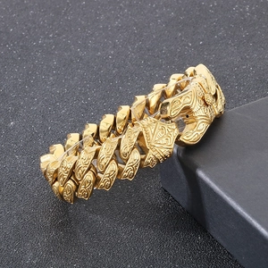 Macro shot of gold-plated chunky chain bracelet with intricate vintage floral patterns