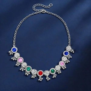 Detail of vintage flower pendant necklace with colorful gems and silver bell tassels