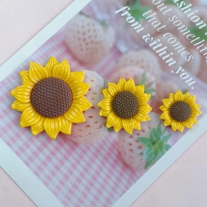Three assorted sizes of yellow sunflower resin accessories on cute strawberry card