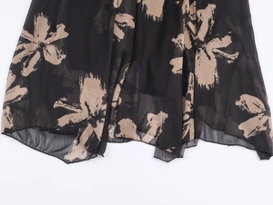 Detailed view of lightweight black chiffon dress hem with beige floral brushstroke prints