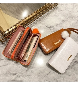 Detail of crocodile pattern wallets showing multiple card slots and faux fur pom-pom