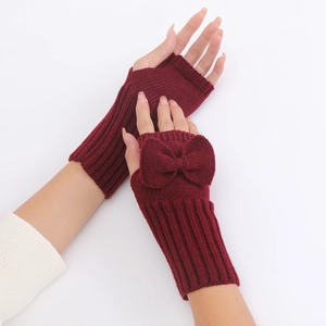Detail of burgundy knitted fingerless gloves with a decorative bow and ribbed texture