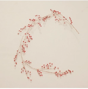 Close-up of golden wire branches with red berry beads for Christmas DIY decoration