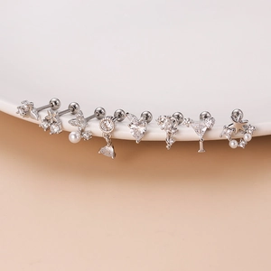 Set of silver stainless steel stud earrings with zircon and pearl details on white plate