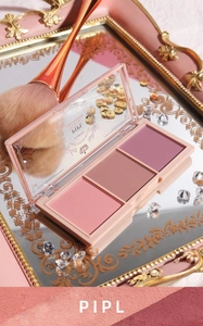 Detailed view of 3-color matte blush palette on a luxury vintage mirror with makeup brushes