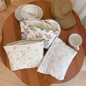 Quilted cotton zipper pouches in bear, floral, and polka dot patterns on wooden table