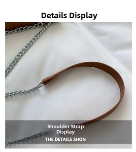 Detail of brown leather shoulder strap with classic silver metal chain links