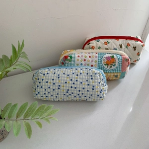 Three quilted floral storage bags in blue check and wildflower prints for makeup or pens