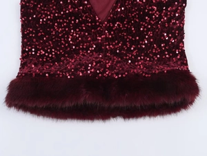 Close-up of a dark red sequin top featuring a luxurious faux fur hem and elegant V-neckline