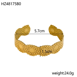 Detail of gold open bangle showing star patterns and dimensions 5.7cm diameter