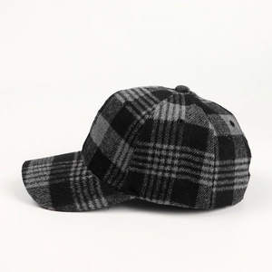 Detailed view of black and grey plaid woolen baseball cap with thick autumn winter texture