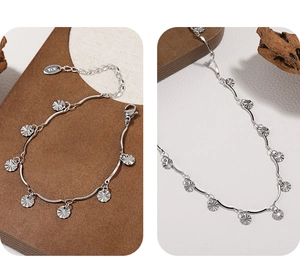Detailed macro of silver chain bracelet with fan-shaped charms and adjustable clasp