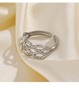 Détail d'une bague tressée argentée ajustable sur un tissu en soie jaune satiné