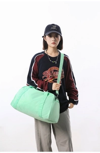 Detailed shot of a mint green large capacity sports fitness travel bag worn by a model