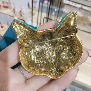 Close-up of the golden metal back and pin clasp structure of the fox animal brooch