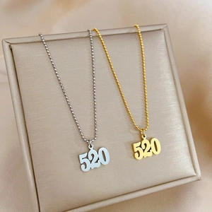 Elegant gold and silver titanium steel necklaces with 520 number pendants on jewelry box
