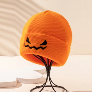Close-up of orange ribbed knit beanie featuring black embroidered pumpkin face pattern