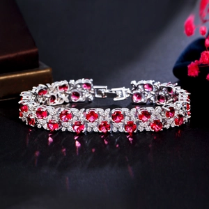 Macro shot of silver tennis bracelet featuring radiant red gemstones and white crystals
