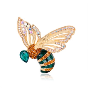 Macro shot of bee brooch with golden hollow wings and colorful rhinestones