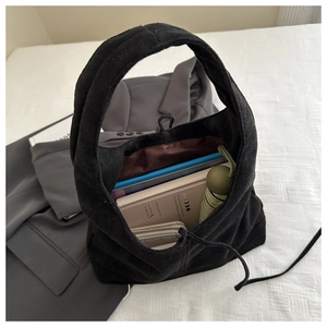 Top view of large black suede tote bag showing spacious interior with daily essentials