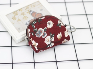 Detail showing floral print fabric and silver key ring on a semi-circle coin purse