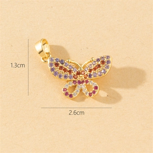 Macro detail of gold butterfly pendant with colorful stones and 2.6cm width measurement