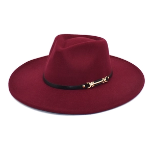 Detail of burgundy wool fedora hat featuring a black band with gold metal horsebit buckle