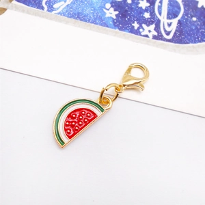 Macro detail of watermelon enamel charm with gold lobster clasp for bags and shoes