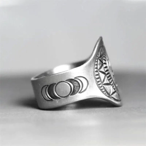 Macro shot of silver ring featuring lunar cycle phases and radial geometric carvings