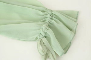 Detail des hellgrünen Chiffon-Ärmels mit Kordelzug-Raffung und Rüschen-Bündchen