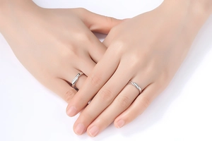 Close-up of minimalist silver couple rings with polished finish on model's fingers