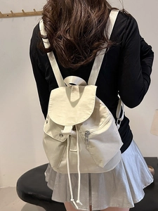 Chic cream nylon drawstring backpack with flap closure shown on a female model